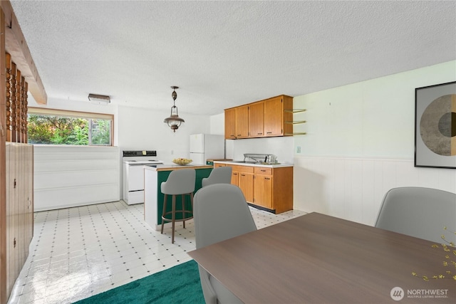 1240 Beach Dr, Camano Island, WA 98282 - dining space featuring light floors, a wainscoted wall, and a textured ceiling