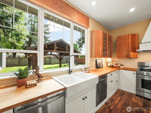 20409 70th St E, Bonney Lake, WA 98391 - kitchen featuring stainless steel appliances, a sink, butcher block counters, dark wood-style flooring, and tasteful backsplash
