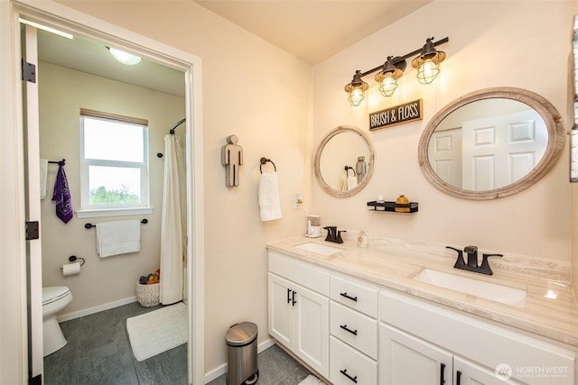 1063 Tamarack Ln, Port Angeles, WA 98362 - bathroom featuring toilet, double vanity, baseboards, and curtained shower