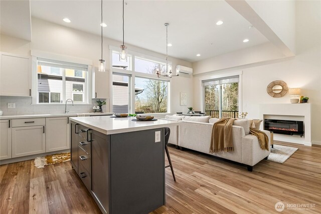 4246 Cameo Ln, Bellingham, WA 98226 - kitchen featuring a wall mounted air conditioner, open floor plan, a center island, light countertops, and light wood finished floors