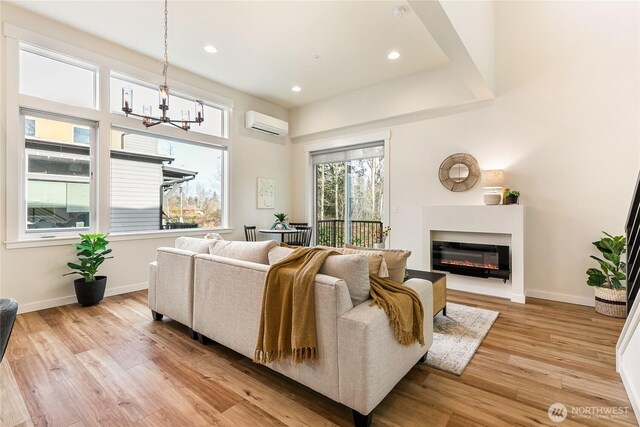 4246 Cameo Ln, Bellingham, WA 98226 - living room featuring a chandelier, light wood finished floors, a wall unit AC, a glass covered fireplace, and recessed lighting