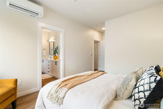 4246 Cameo Ln, Bellingham, WA 98226 - bedroom with a wall mounted AC, light wood finished floors, baseboards, connected bathroom, and recessed lighting