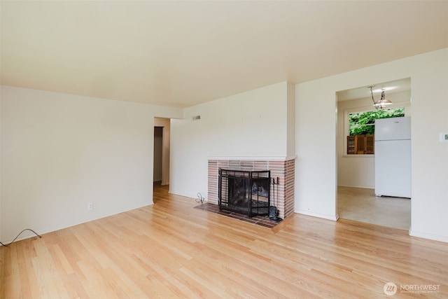 2409 Veldee Ave, Bremerton, WA 98312 - unfurnished living room featuring wood finished floors, a tile fireplace, and baseboards