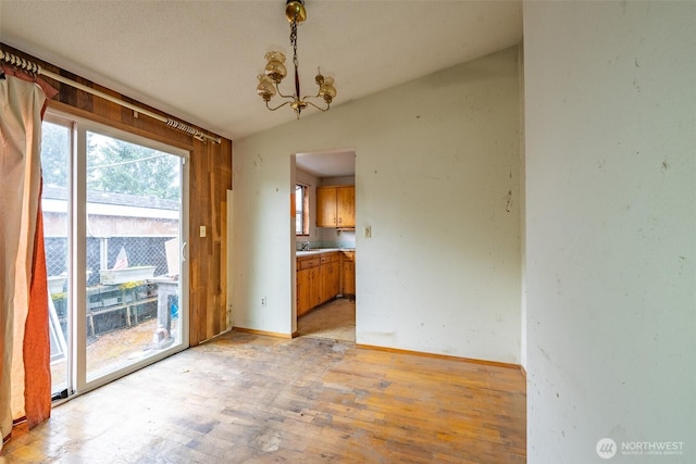 1216 E 70th St, Tacoma, WA 98404 - unfurnished dining area featuring a chandelier, light wood finished floors, and baseboards
