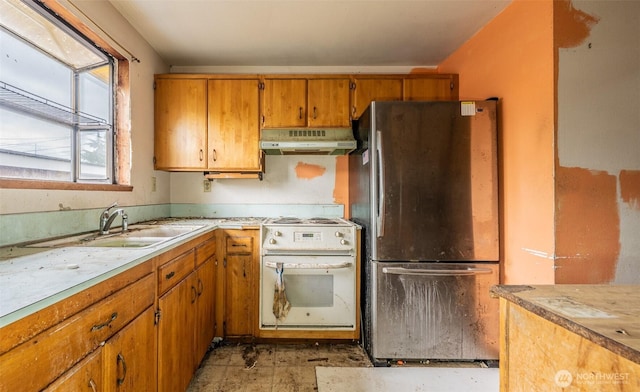 1216 E 70th St, Tacoma, WA 98404 - kitchen featuring freestanding refrigerator, white range with electric stovetop, under cabinet range hood, light countertops, and brown cabinets