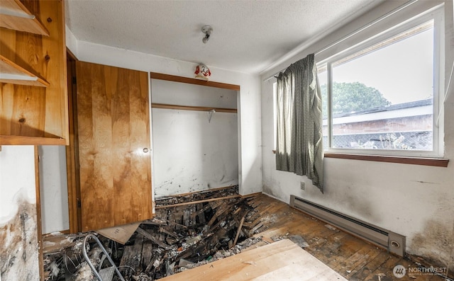 1216 E 70th St, Tacoma, WA 98404 - unfurnished bedroom featuring a baseboard radiator, a closet, and a textured ceiling