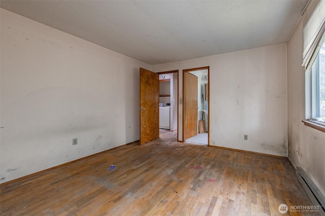 1216 E 70th St, Tacoma, WA 98404 - unfurnished room with baseboard heating, washer / clothes dryer, hardwood / wood-style floors, and plenty of natural light