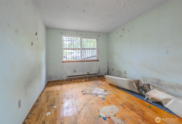 1216 E 70th St, Tacoma, WA 98404 - spare room with baseboard heating and hardwood / wood-style flooring