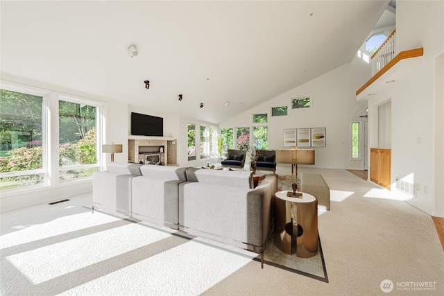 5501 55th St SE, Auburn, WA 98092 - carpeted living area featuring a tiled fireplace, high vaulted ceiling, and healthy amount of natural light