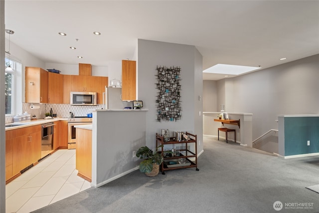 22756 SE 13th Ln Unit C6, Sammamish, WA 98075 - kitchen featuring stainless steel appliances, a skylight, light countertops, recessed lighting, and tasteful backsplash