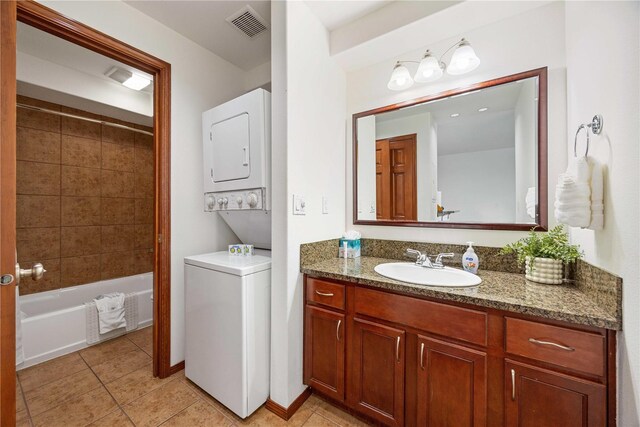 322 W Woodin Ave Unit 632, Chelan, WA 98816 - full bathroom with stacked washer and clothes dryer, tile patterned flooring, vanity, washtub / shower combination, and baseboards
