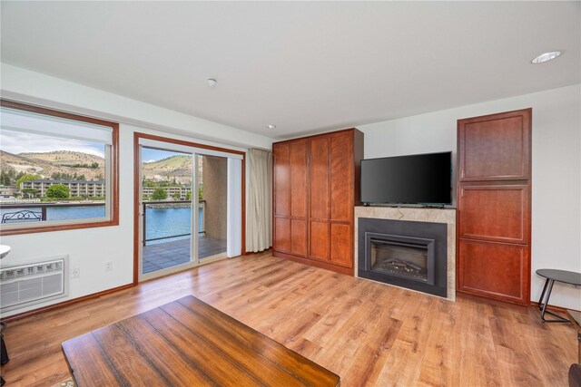 322 W Woodin Ave Unit 632, Chelan, WA 98816 - unfurnished living room with light wood-style flooring, a fireplace, baseboards, and a wall mounted AC