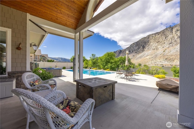 35 N Shore Dr, Orondo, WA 98843 - fenced backyard with a hot tub, outdoor dining area, a mountain view, and a patio area