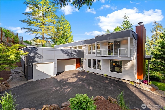 18510 NE 15th Pl, Bellevue, WA 98008 - back of property featuring a balcony, an attached garage, asphalt driveway, and a chimney