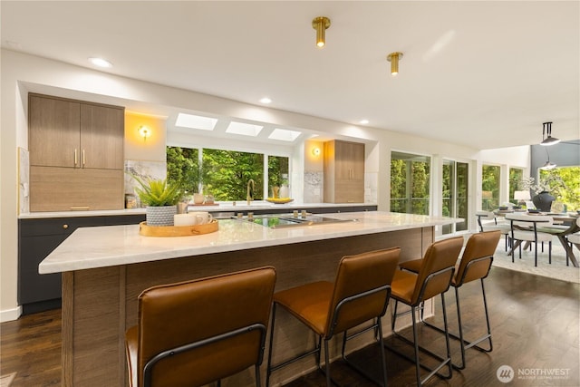 18510 NE 15th Pl, Bellevue, WA 98008 - kitchen featuring black electric stovetop, decorative backsplash, a breakfast bar, a center island, and recessed lighting