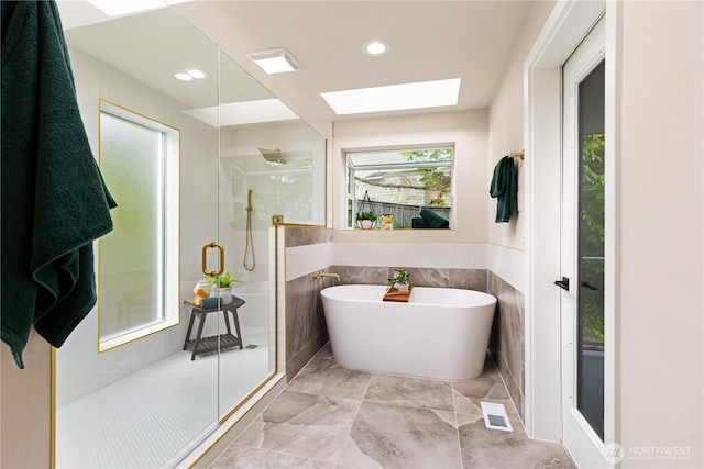 18510 NE 15th Pl, Bellevue, WA 98008 - bathroom featuring a skylight, a shower stall, a soaking tub, tile walls, and recessed lighting