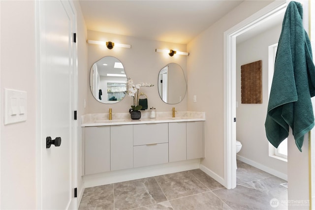 18510 NE 15th Pl, Bellevue, WA 98008 - bathroom with double vanity, toilet, tile patterned floors, and baseboards