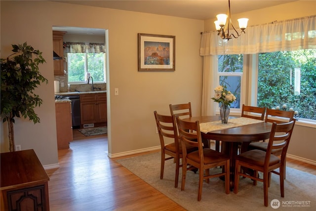 22015 SE 244th Pl, Maple Valley, WA 98038 - dining area with light wood-style floors, a chandelier, and baseboards