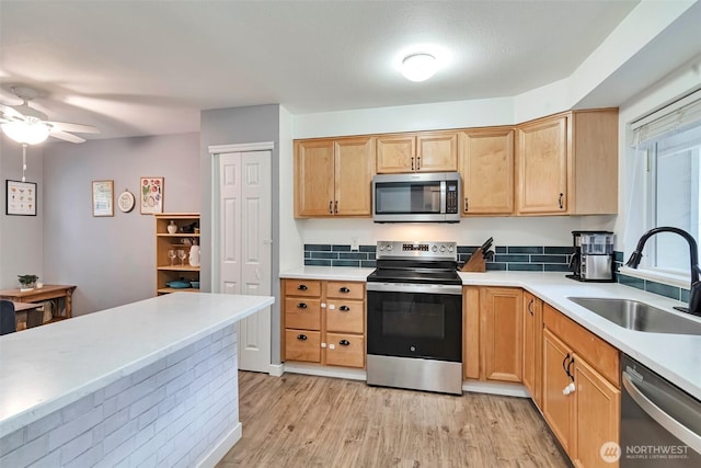 1131 115th St SW Unit M2, Everett, WA 98204 - kitchen with stainless steel appliances, a sink, light wood finished floors, light countertops, and a ceiling fan