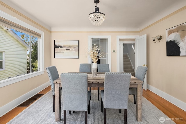 6813 17th Ave NE, Seattle, WA 98115 - dining area featuring a chandelier, wood finished floors, baseboards, and stairway
