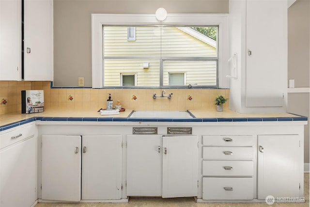 6813 17th Ave NE, Seattle, WA 98115 - kitchen with white cabinetry, backsplash, a sink, and tile countertops