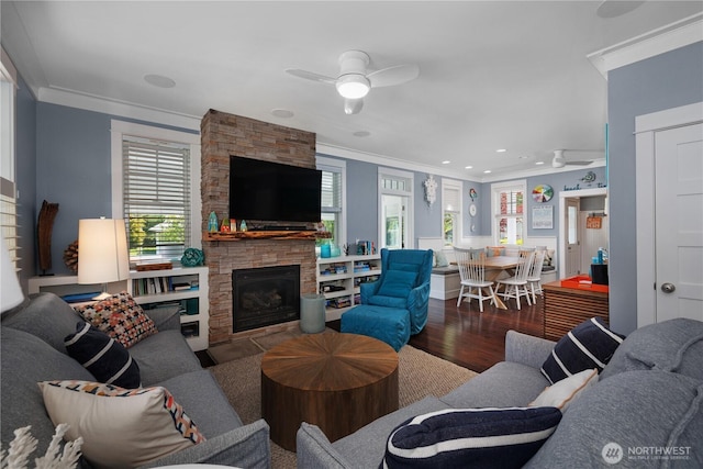228 Meriweather St, Pacific Beach, WA 98571 - living area with ceiling fan, crown molding, wood finished floors, a stone fireplace, and plenty of natural light
