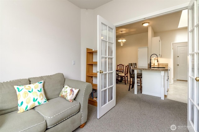 1002 9th Ave SE Unit C-201, Puyallup, WA 98372 - living room with light carpet, french doors, and a chandelier