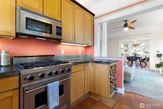 2011 E Cherry St, Seattle, WA 98122 - kitchen with appliances with stainless steel finishes, dark countertops, ceiling fan, tile patterned flooring, and a peninsula