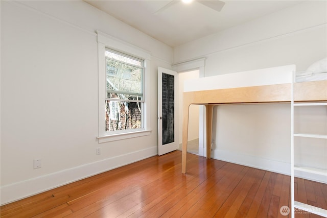 2011 E Cherry St, Seattle, WA 98122 - unfurnished bedroom featuring wood-type flooring, baseboards, and a ceiling fan
