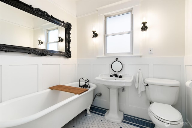 2011 E Cherry St, Seattle, WA 98122 - bathroom with a freestanding tub, a decorative wall, wainscoting, toilet, and tile patterned floors