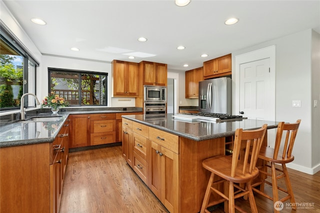 15102 93rd Pl NE, Bothell, WA 98011 - kitchen featuring appliances with stainless steel finishes, a sink, a kitchen island, light wood-style floors, and recessed lighting