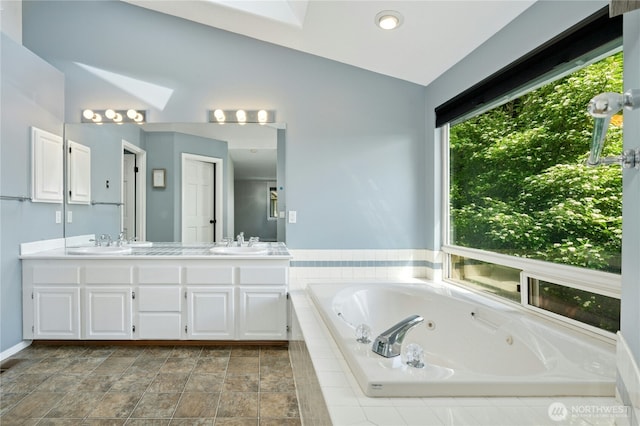 15102 93rd Pl NE, Bothell, WA 98011 - bathroom with vaulted ceiling, double vanity, a whirlpool tub, a skylight, and baseboards