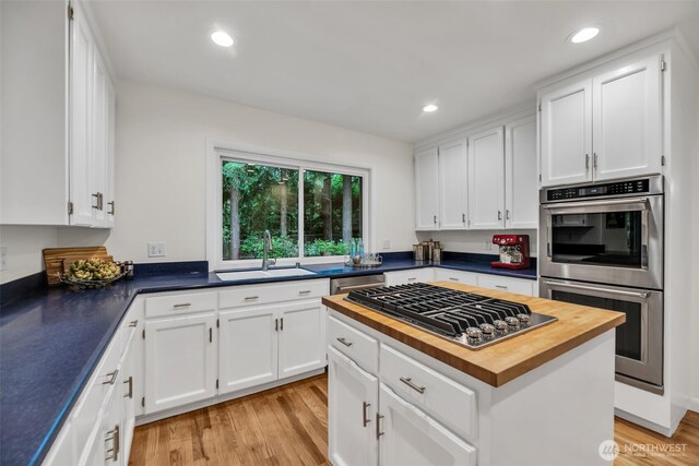 2714 Sahalee Dr E, Sammamish, WA 98074 - kitchen with butcher block counters, a sink, appliances with stainless steel finishes, light wood-style flooring, and white cabinets