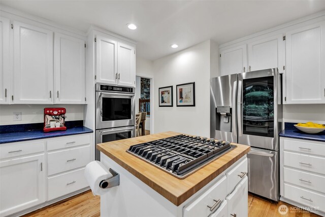 2714 Sahalee Dr E, Sammamish, WA 98074 - kitchen featuring butcher block countertops, appliances with stainless steel finishes, white cabinetry, recessed lighting, and a center island