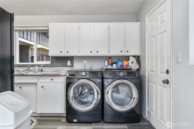 8909 Hipkins Rd SW, Lakewood, WA 98498 - laundry area featuring cabinet space, washing machine and clothes dryer, and wood finished floors