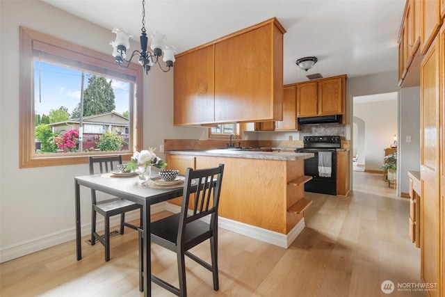 1001 Elm St, Centralia, WA 98531 - kitchen featuring electric range, under cabinet range hood, light wood-type flooring, and a chandelier