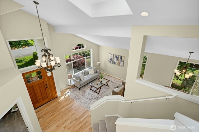 32910 NE 40th Pl, Carnation, WA 98014 - living room with a chandelier, vaulted ceiling, light wood-type flooring, and a skylight