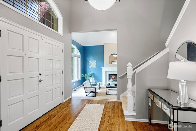 2110 216th Pl NE, Sammamish, WA 98074 - entryway featuring a high ceiling, wood finished floors, baseboards, a glass covered fireplace, and stairway