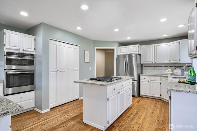 2110 216th Pl NE, Sammamish, WA 98074 - kitchen with appliances with stainless steel finishes, a sink, light wood finished floors, light stone counters, and recessed lighting