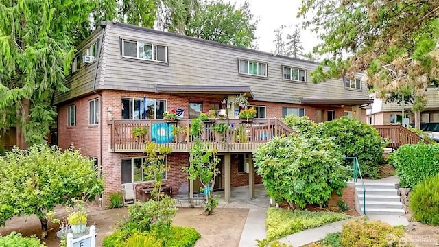 3834 175th Ave NE Unit G16, Redmond, WA 98052 - view of front of house with brick siding, a patio area, a deck, and stairs
