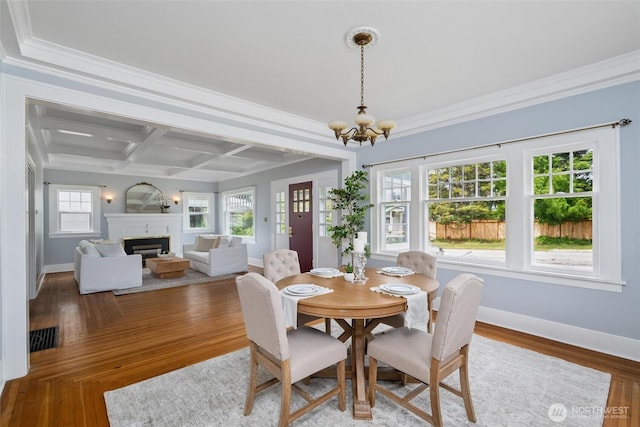 2828 Sunset Dr, Bellingham, WA 98225 - dining area with a chandelier, coffered ceiling, baseboards, ornamental molding, and a glass covered fireplace