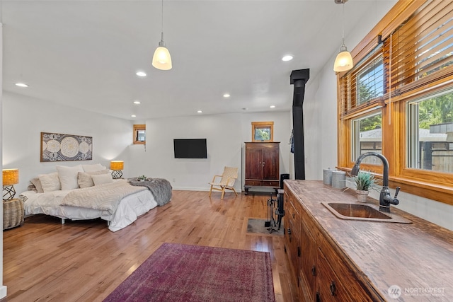 7510 Fauntleroy Way SW, Seattle, WA 98136 - bedroom featuring a sink, light wood-type flooring, recessed lighting, and a wood stove