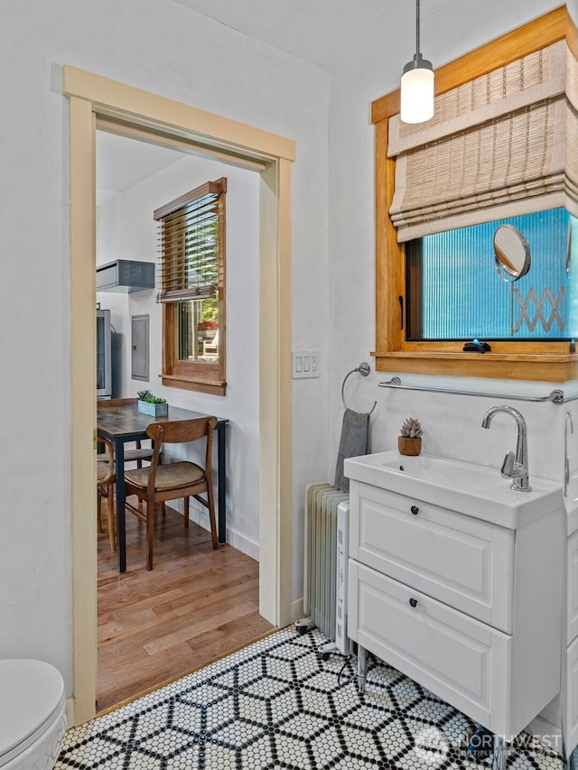 7510 Fauntleroy Way SW, Seattle, WA 98136 - bathroom with toilet, radiator, electric panel, wood finished floors, and vanity
