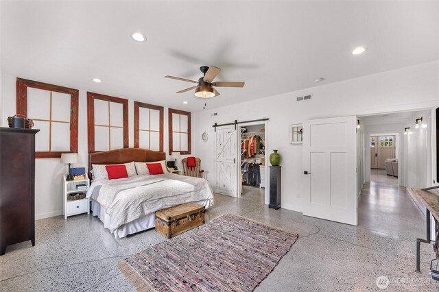 2495 River Rock Dr, Everson, WA 98247 - bedroom featuring speckle patterned floor, a barn door, baseboards, recessed lighting, and a walk in closet