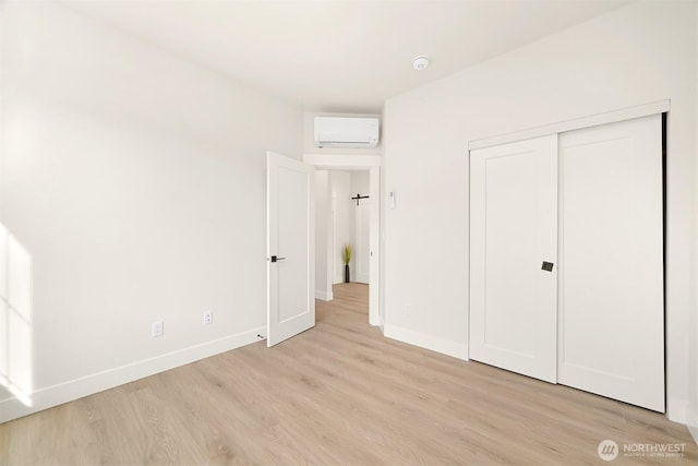 710 E 4th St, Nooksack, WA 98276 - unfurnished bedroom with a wall unit AC, light wood-style flooring, baseboards, and a closet