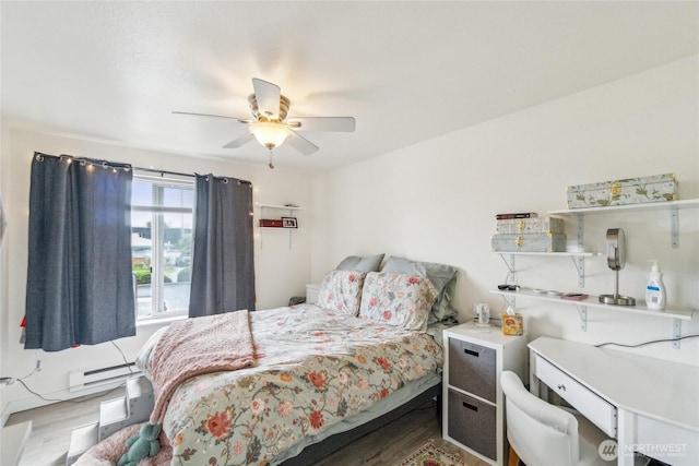 903 N 130th St Unit 113, Seattle, WA 98133 - bedroom featuring baseboard heating, wood finished floors, and ceiling fan