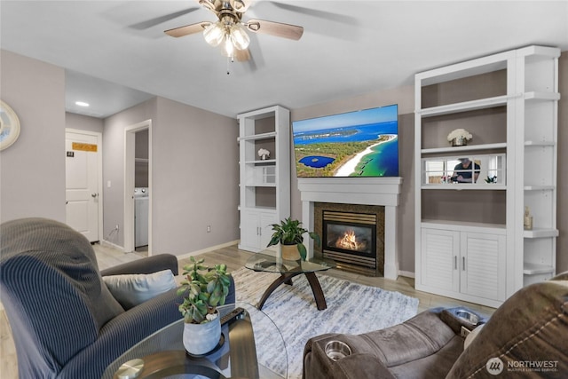 1921 76th Ave SE, Lake Stevens, WA 98258 - living area with a ceiling fan, a glass covered fireplace, light wood finished floors, and baseboards