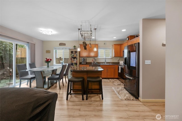 1921 76th Ave SE, Lake Stevens, WA 98258 - kitchen featuring black fridge with ice dispenser, dark countertops, plenty of natural light, a sink, and recessed lighting