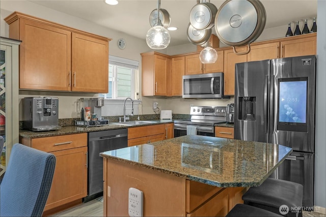 1921 76th Ave SE, Lake Stevens, WA 98258 - kitchen with appliances with stainless steel finishes, a sink, a kitchen bar, dark stone counters, and a kitchen island