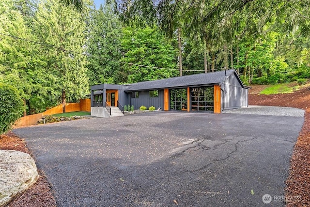 19433 SE 128th St, Renton, WA 98059 - mid-century inspired home with asphalt driveway, a wooded view, and board and batten siding